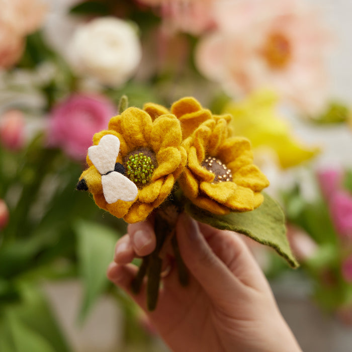 Small felt sunflower bouquet with a felt bee in a clear glass vase, made from recycled materials.