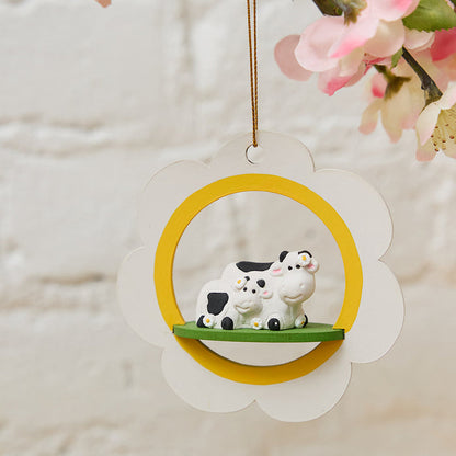 Hand-carved wood ornament of mama and baby cow resting on a white daisy – handmade in Peru