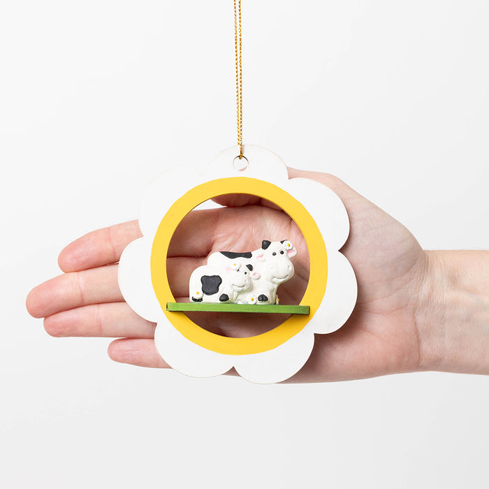 Artisan-crafted cow ornament with painted details and smooth wood finish