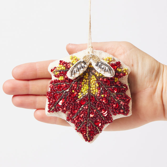 Detailed beaded maple leaf ornament with dangling samaras, a symbol of nature’s bounty and autumn elegance.