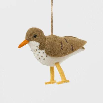 Bring a touch of the shoreline to your holiday décor with our delightful Spotted Sandpiper Ornament. Carefully handcrafted from eco-friendly wool felt, this charming bird captures the distinctive features of the beloved sandpiper, from its warm brown plumage and bright orange beak to its delicate spotted breast.