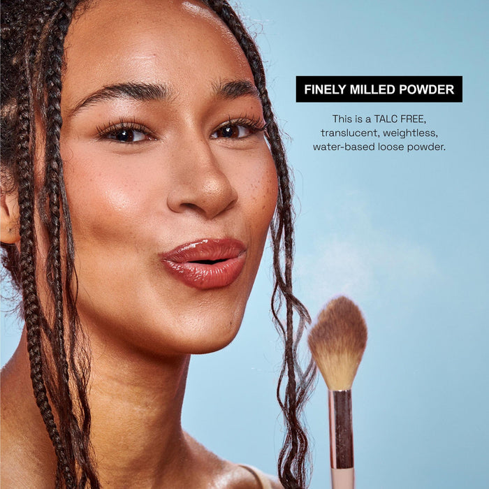 Finely milled talc-free translucent loose powder brushing onto skin