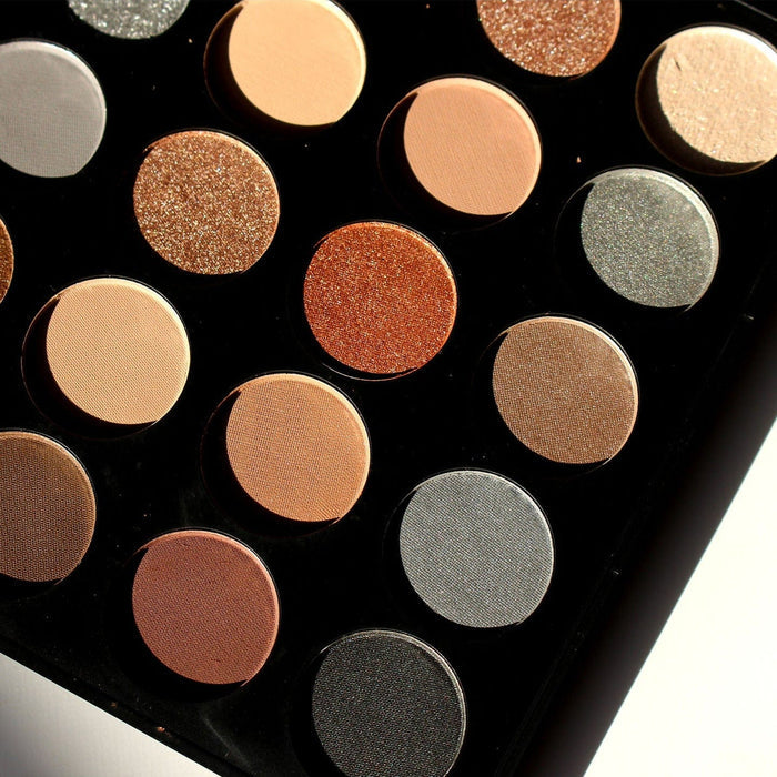 Macro detail of pressed powder texture in copper, beige, bronze, grey, and charcoal shades
