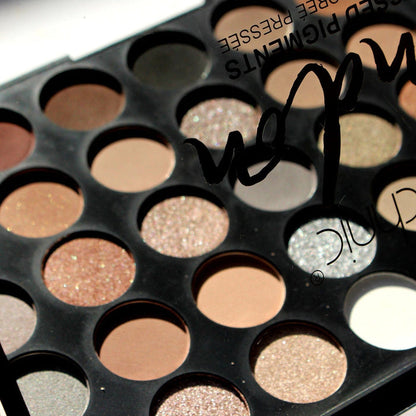 View through clear lid of Technic London Pressed Pigment Palette showing tan, champagne, pink, and silver shades