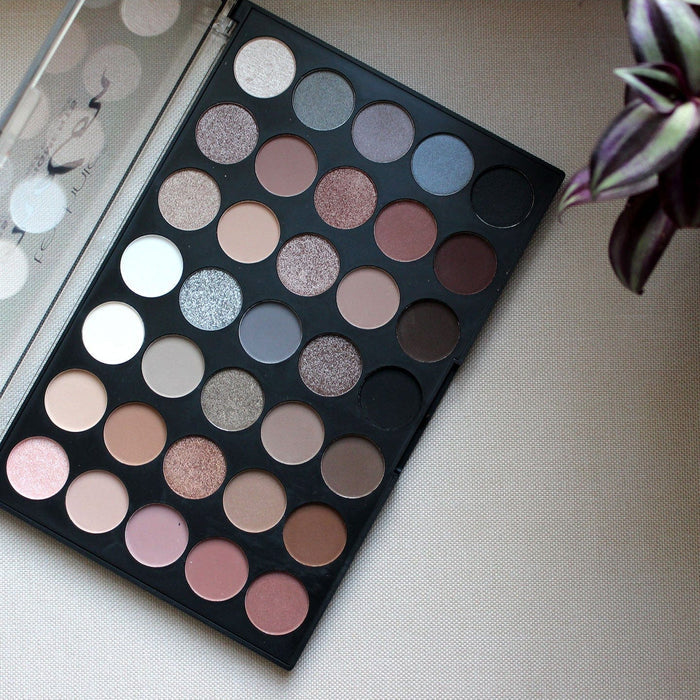 Technic London Pressed Pigment Palette on beige fabric with plant leaf styling
