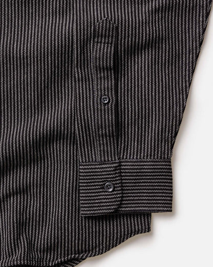 Close-up detail of The Jack in Roped Black Indigo showing roped indigo stripe fabric texture, button placket, and barrel cuff